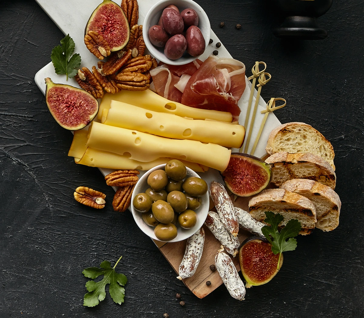 planche-mixte-charcuterie-fromages-affines-fruits-et-olives-sur-planche-en-bois